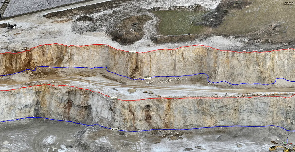 Aerial view of an open-pit mine wall with digitized breaklines highlighting crest and toe edges to improve DTM accuracy.